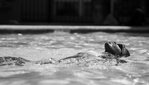 Grayscale Photo of Person Swimming