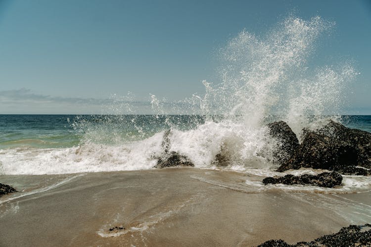 Ocean Waves Crashing On Black Rocks