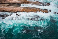 Brown Rock Formation Beside Body of Water