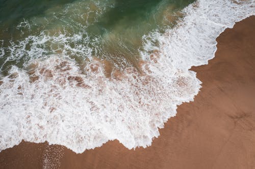An Ocean Waves Crashing on Beach Sand