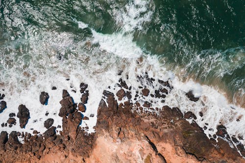 Top View of Waves Crashing on Rocky Shore