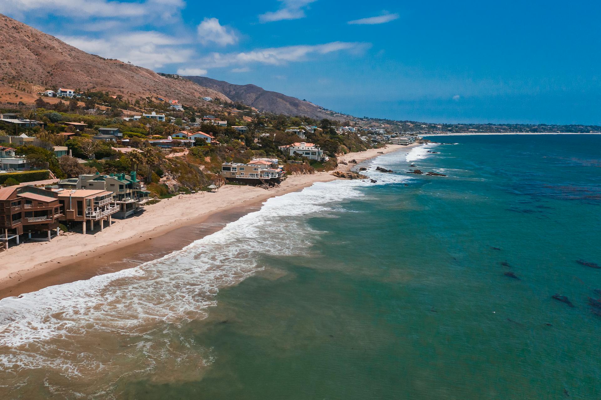 A breathtaking aerial view of Malibu's beachfront homes along the scenic coastline.