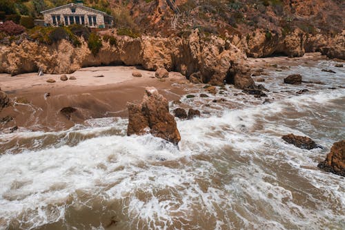 Strong Beach Waves Causing Erosion in the Rocky Shore 