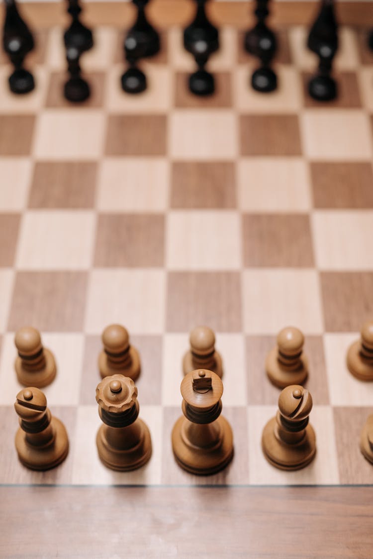 Wooden Chess Pieces On Chessboard