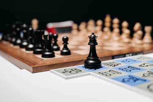 Free A focused view of a chessboard with the black queen prominently displayed in the foreground. Stock Photo