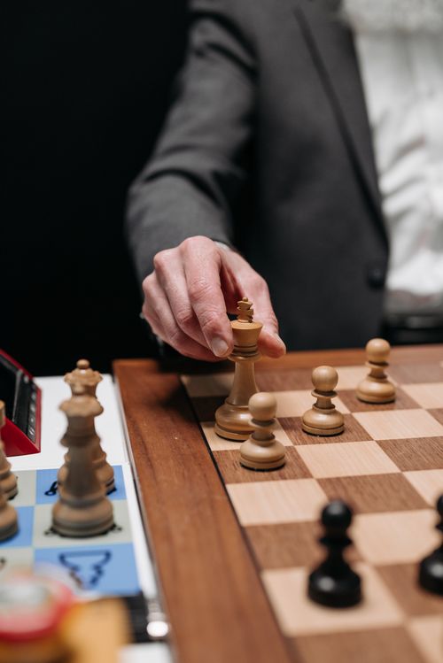 Free Close-up of a person making a strategic move on a chessboard during an intense game. Stock Photo