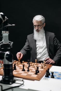 A senior scientist engages in a chess game with a robot, showcasing innovation.