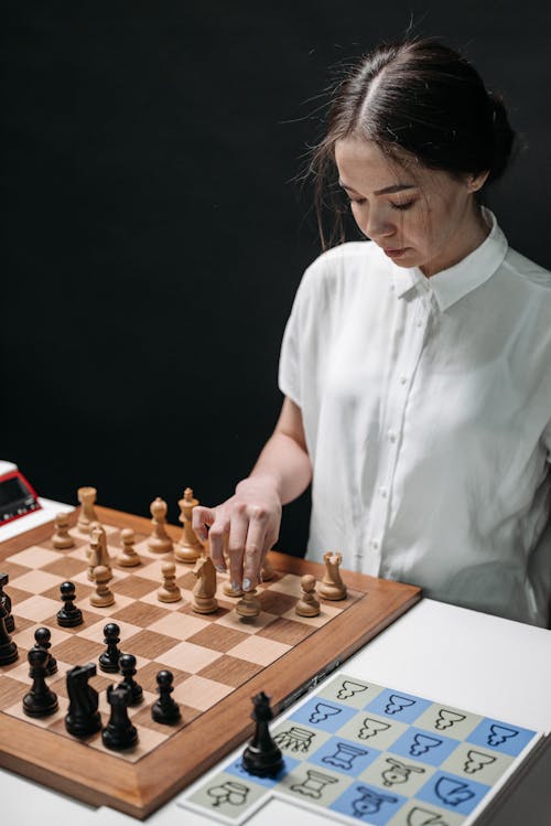 Woman Wearing a White Button Up Shirt Playing Chess