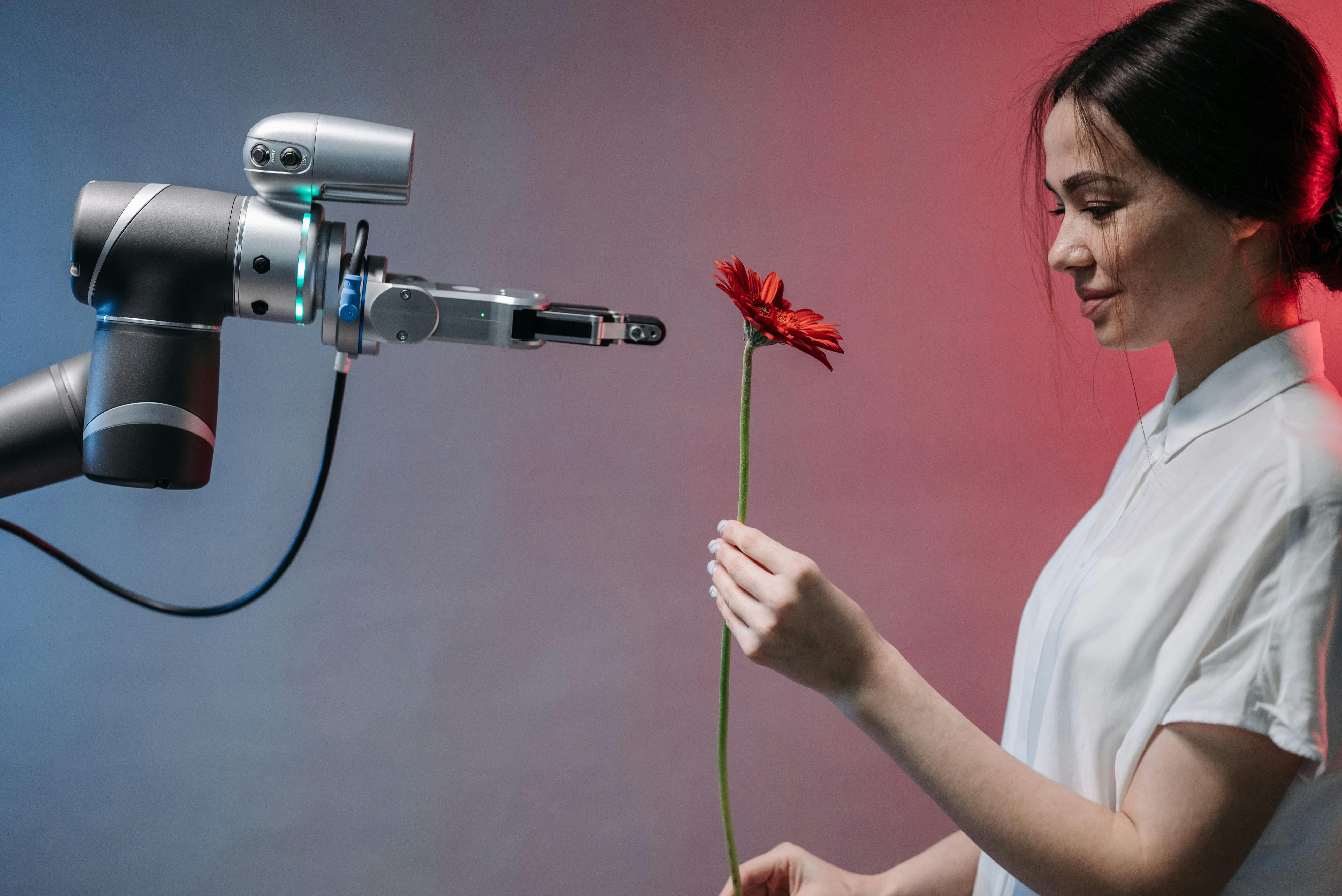 a smiling woman in white shirt holding a red flower