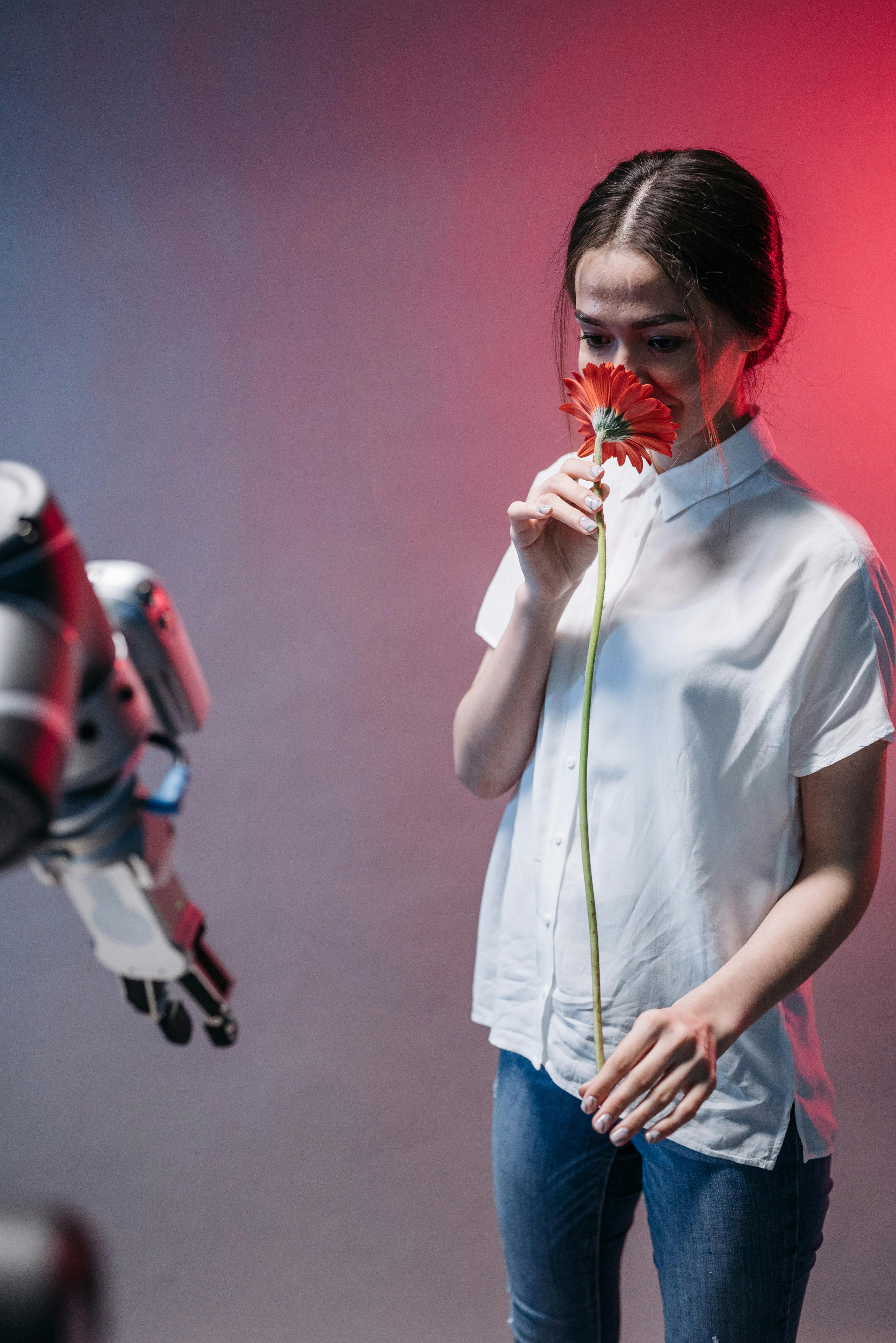 woman smelling a red flower