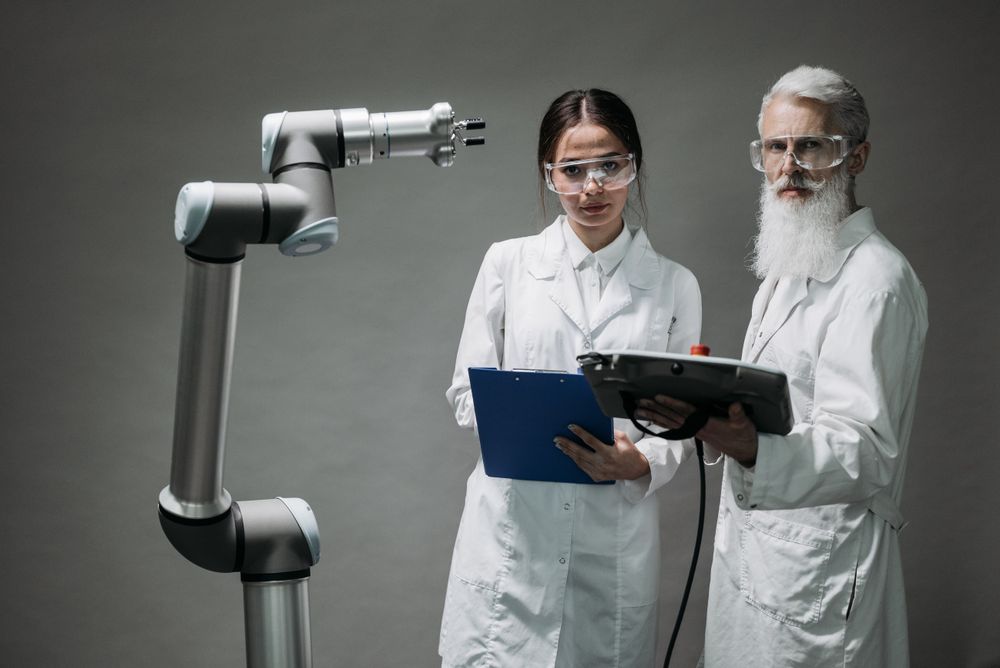 Engineering students working with a robotic arm in a technology laboratory