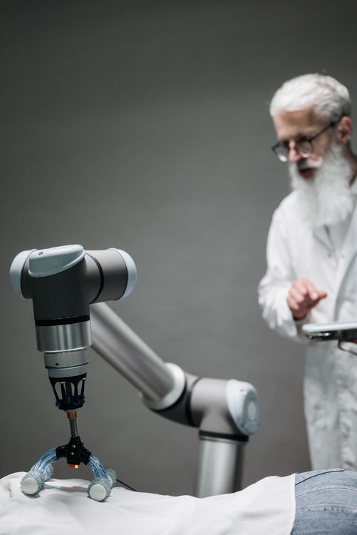 Cientista supervisionando equipamento cirúrgico robótico em sala de operações Cientista supervisionando equipamento cirúrgico robótico em sala de operações