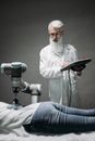 Man in White Robe Holding Black and Gray Hair Blower