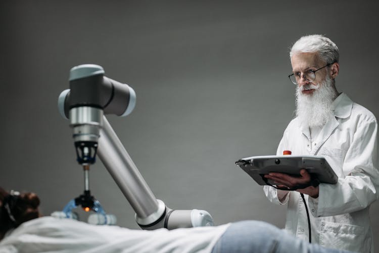  An Elderly Man Controlling A Robot