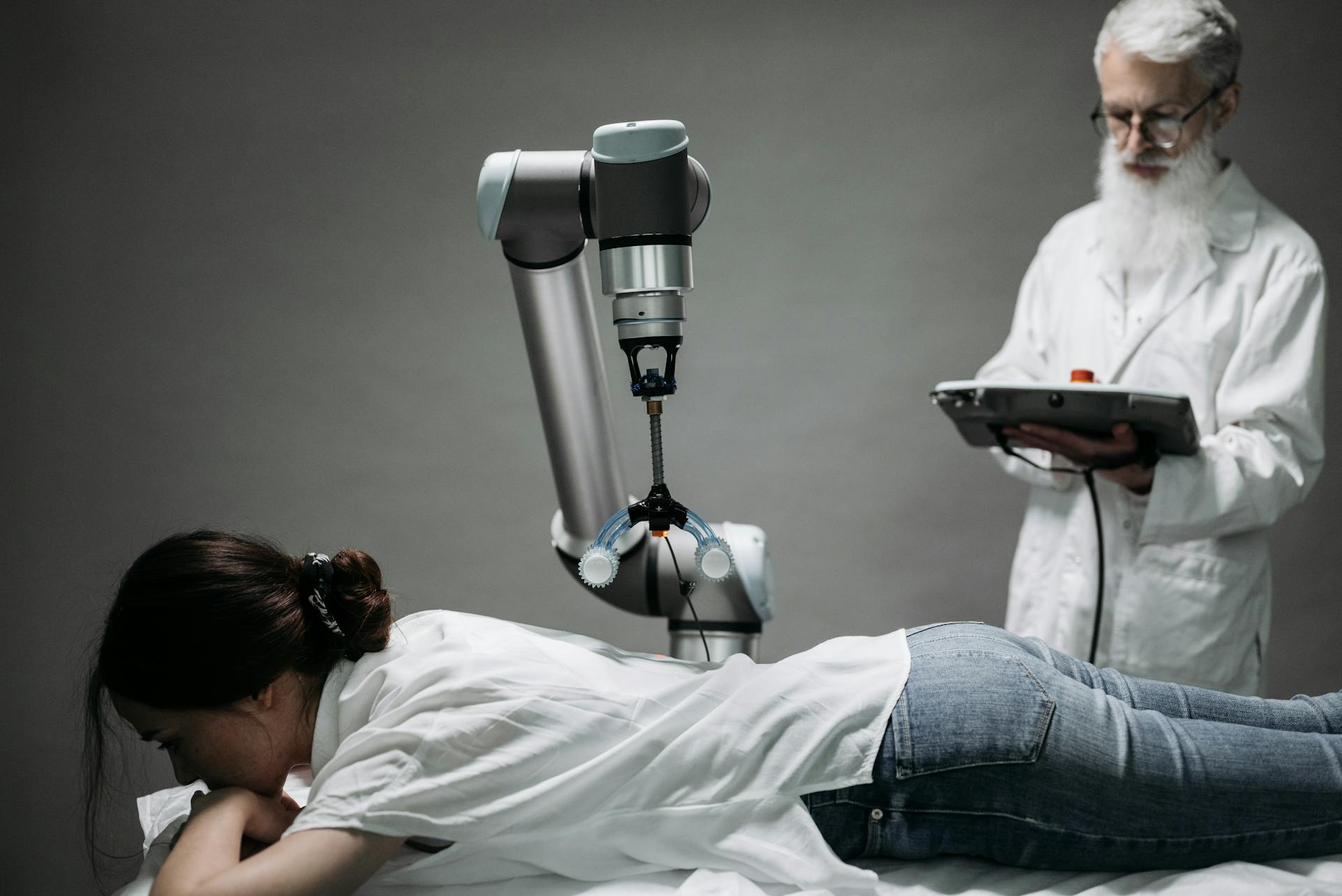 Woman Lying on a Massage Table and Getting Treated by a Robot