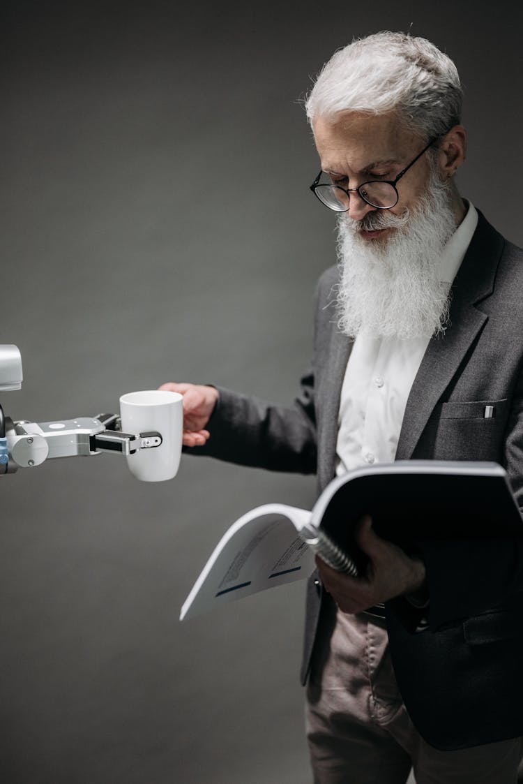 Reading Man Taking Coffee From A Robot