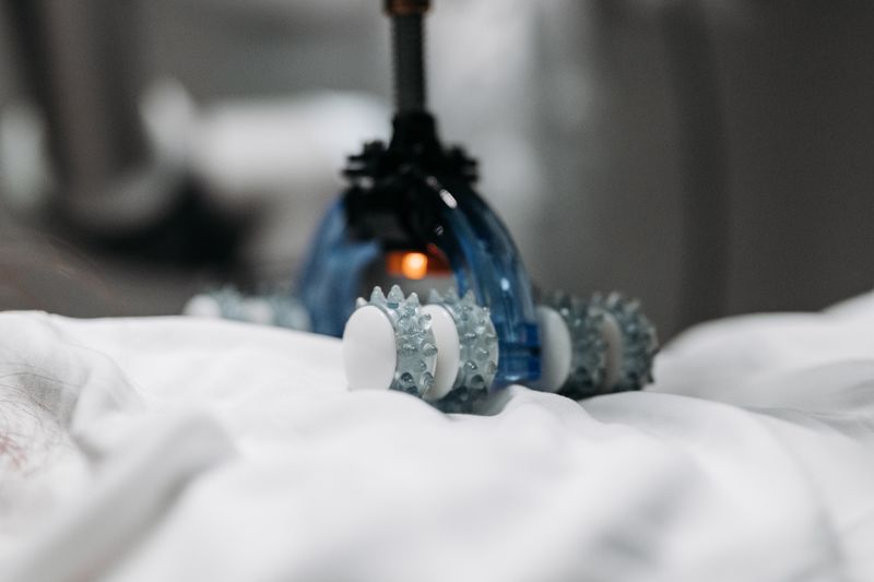 High-tech massage gadget resting on white fabric, showcasing innovation in relaxation technology.