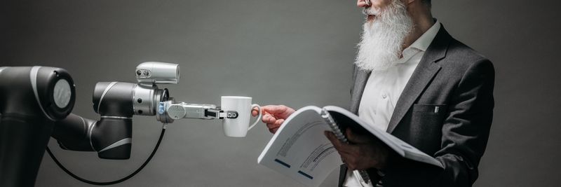 A scientist interacts with a robot helper, demonstrating modern technological innovation.