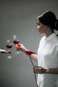 A woman interacts with a robotic arm holding wine glasses, merging technology and lifestyle.