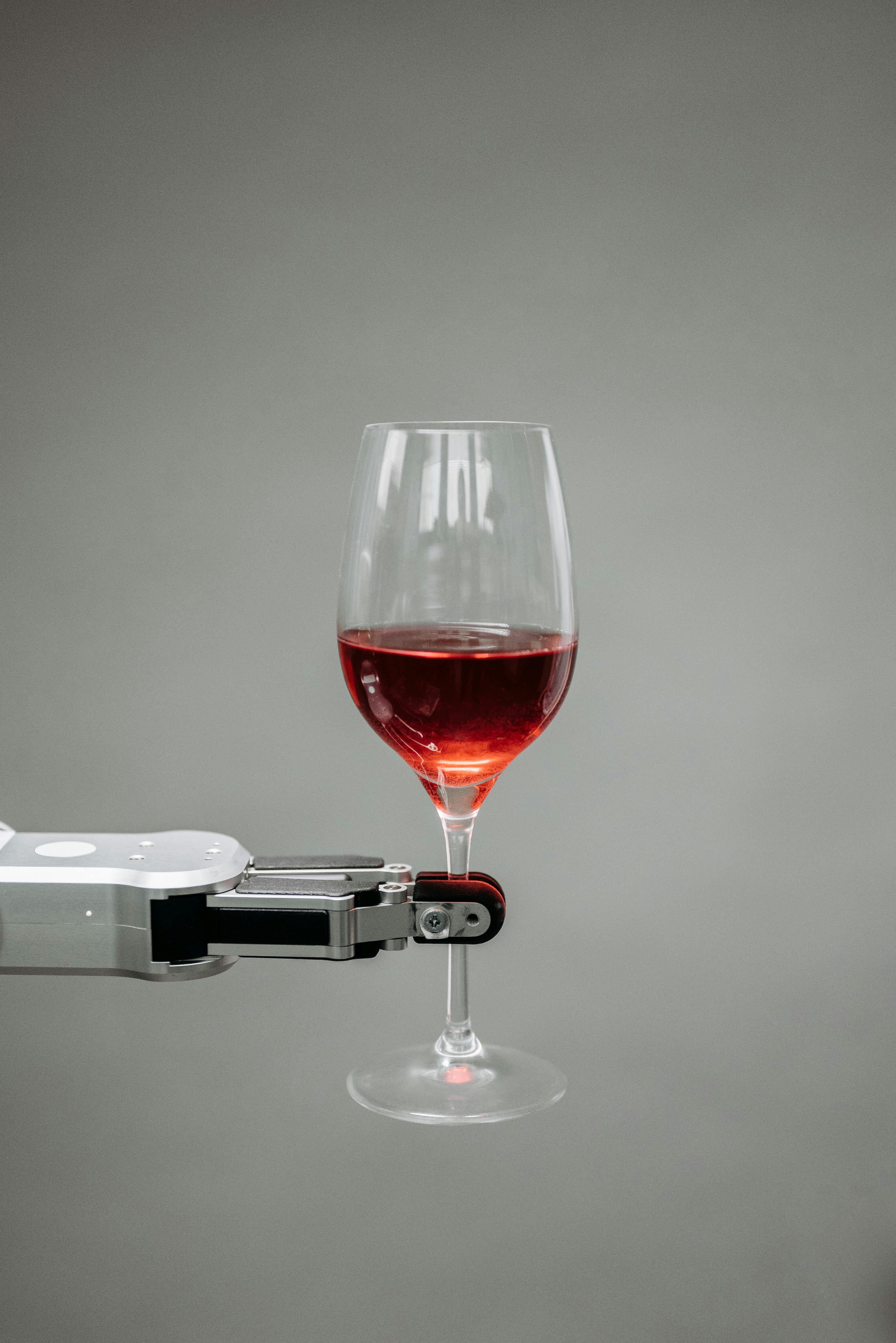 robot holding a glass of red wine