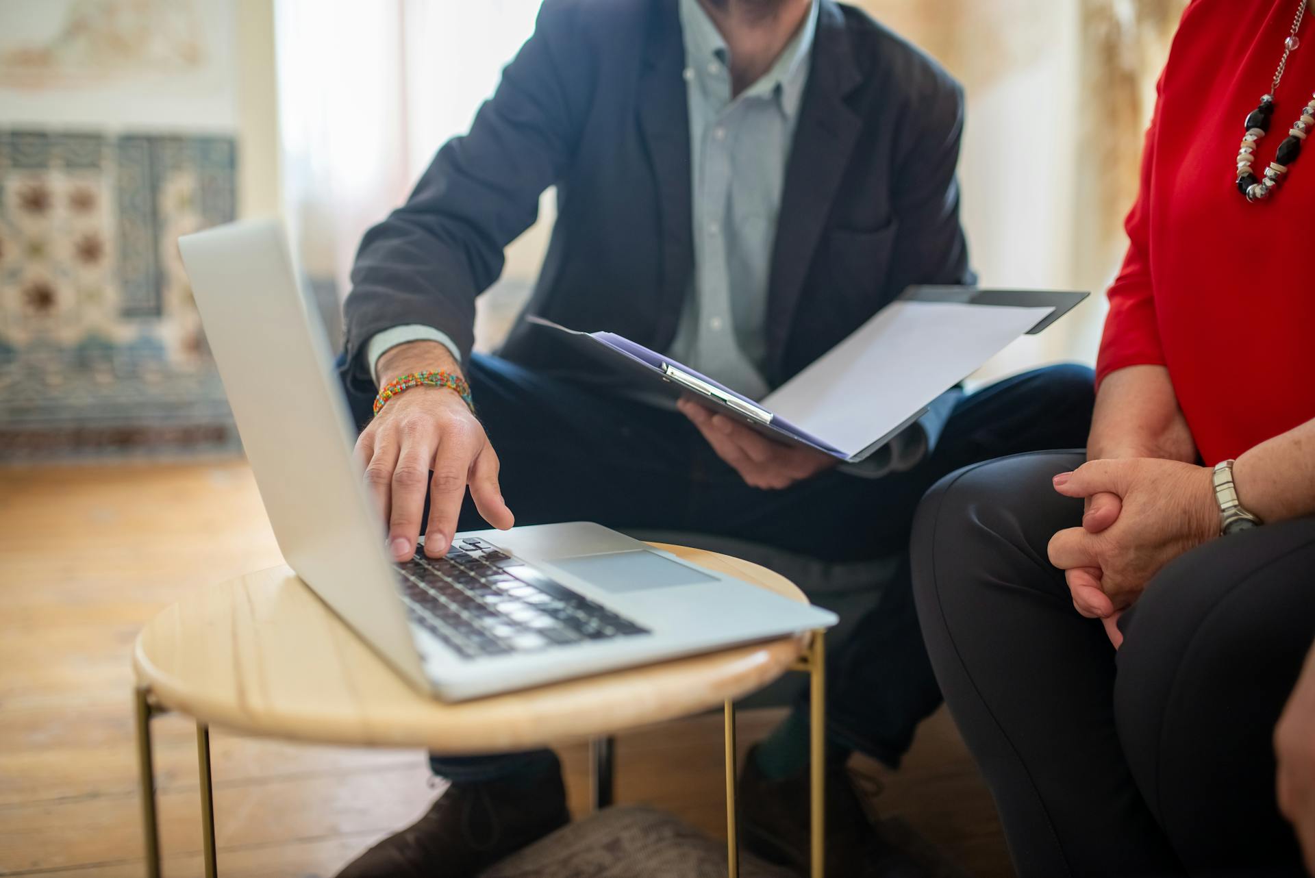 Professional meeting with a laptop and documents in an office setting.