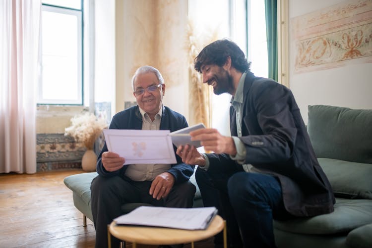 A Bearded Man Sitting On A Couch With An Elderly Client