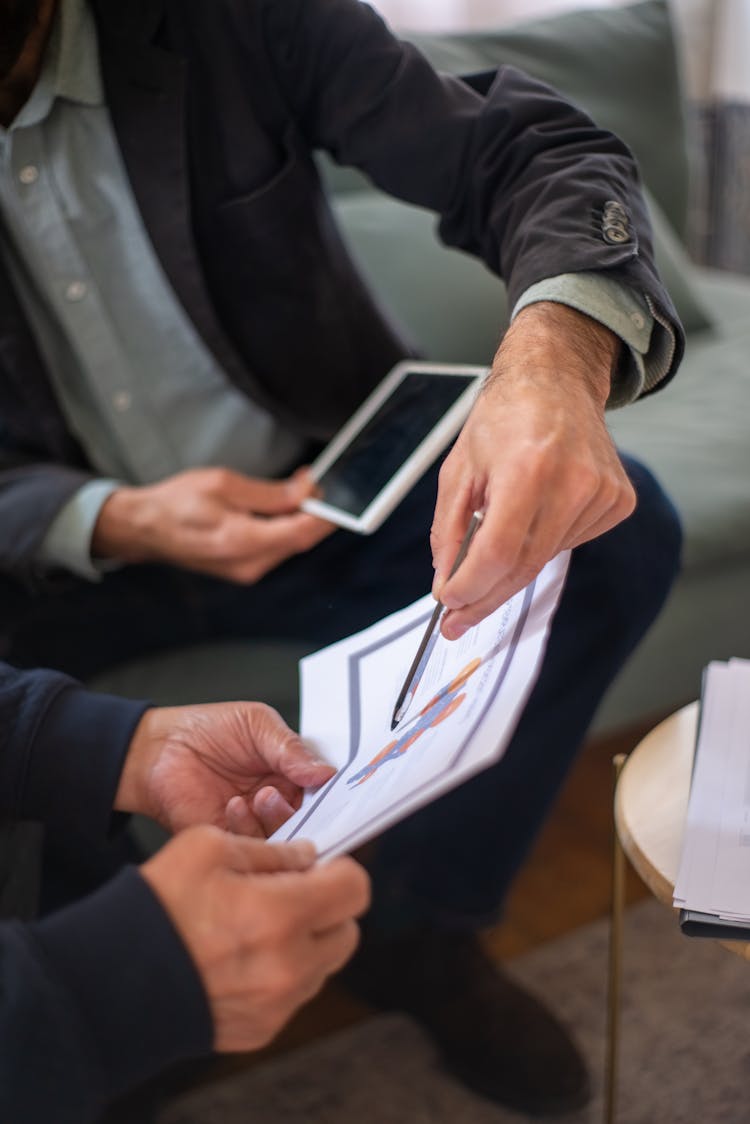 Man Holding A Pen Pointing On A Document