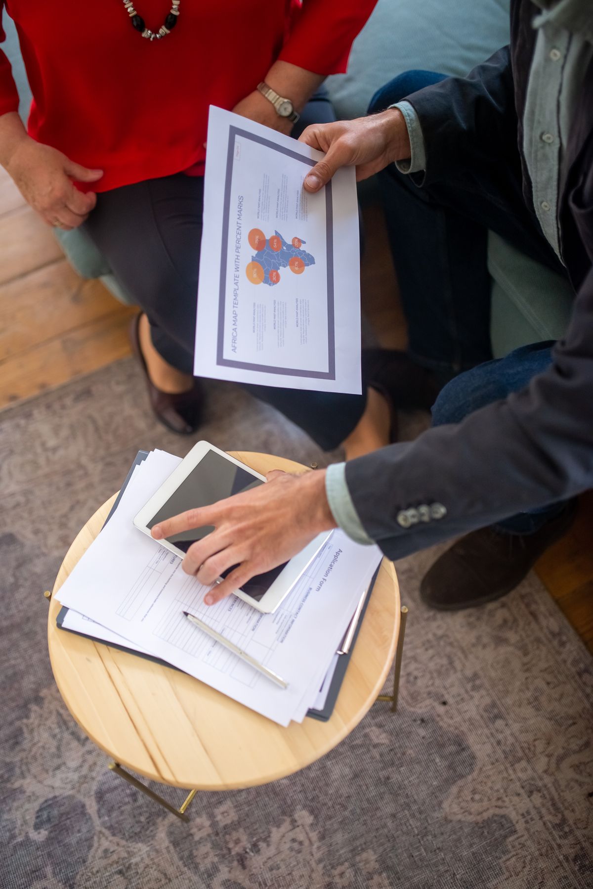 Colleagues discussing documents and a tablet around a table
