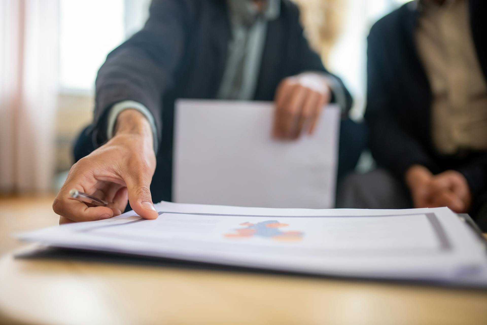 Close-up of a businessman reviewing important documents at a desk in an office setting.