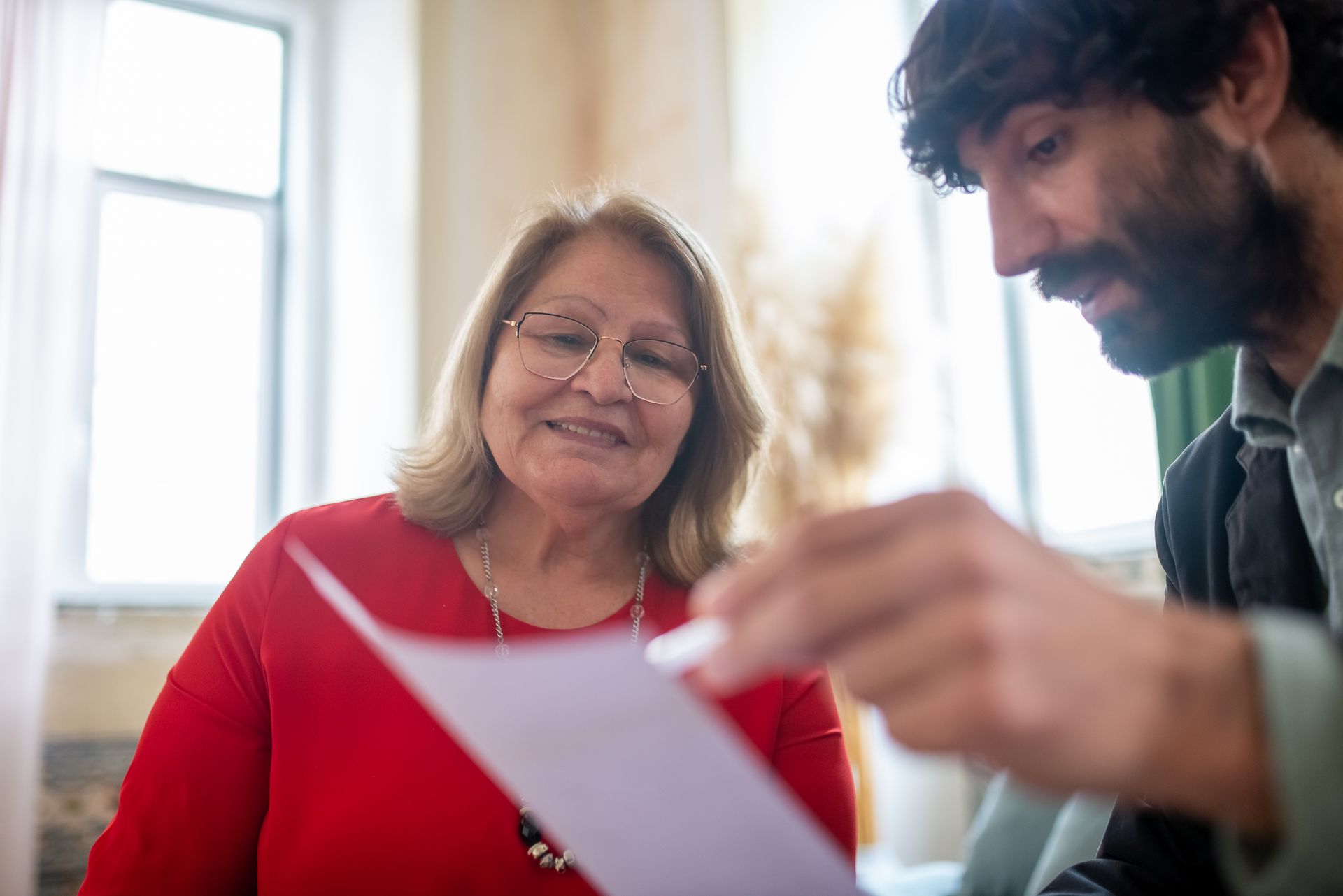 Bearded Man Presenting Paperwork to an Elderly Woman
