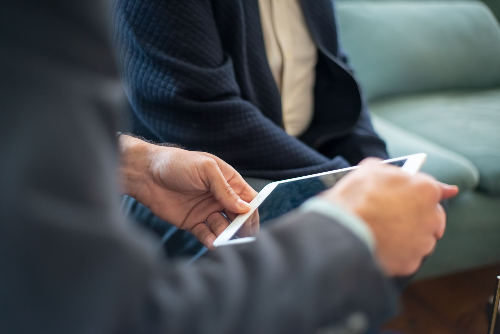 Man Holding a Tablet Next to a Client