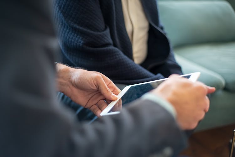 Man Holding A Tablet Next To A Client