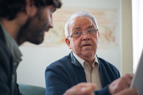 Free Elderly man with eyeglasses in a thoughtful discussion in Portugal indoors. Stock Photo