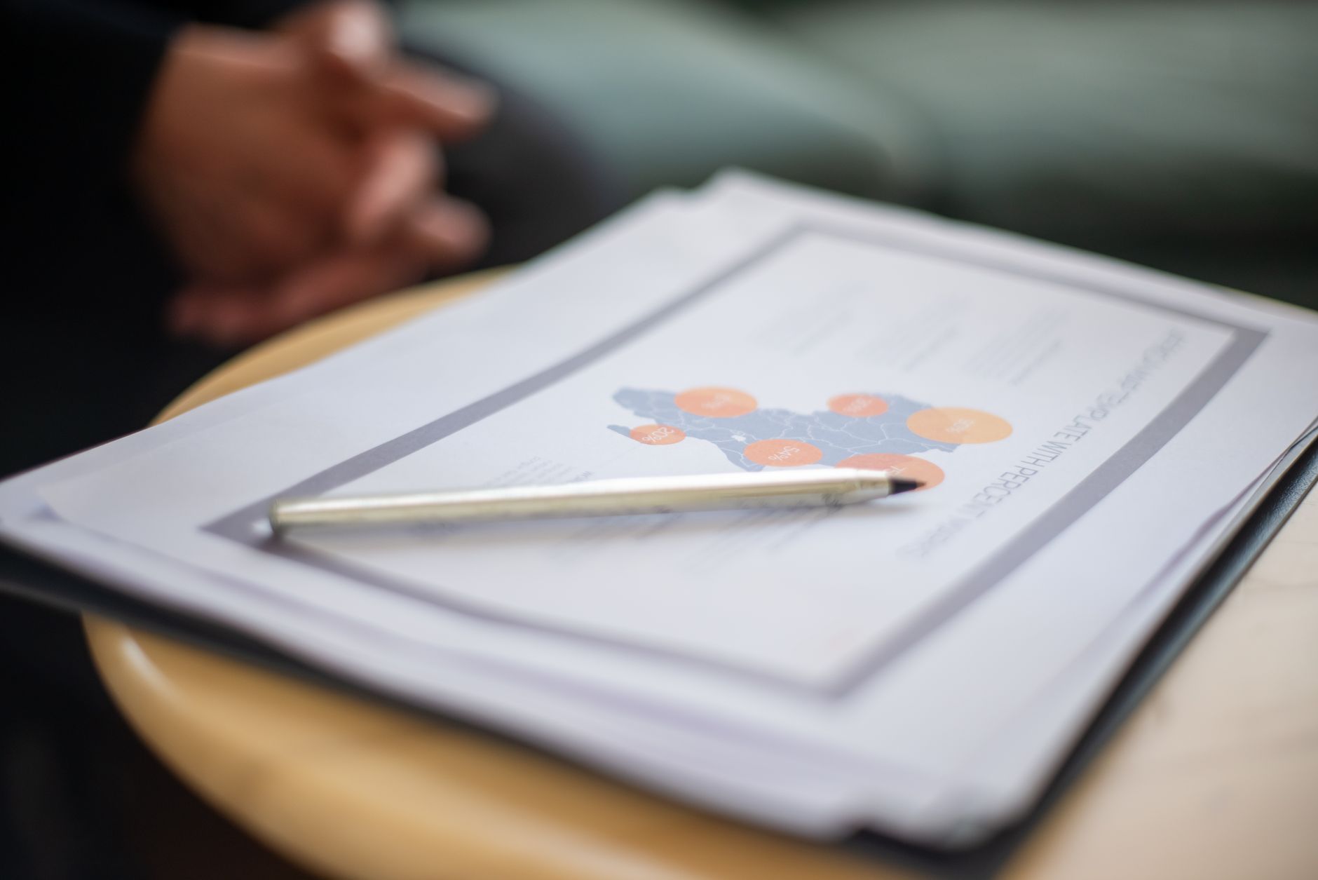 Close-up of business document and pen on a round table, perfect for office and corporate themes.