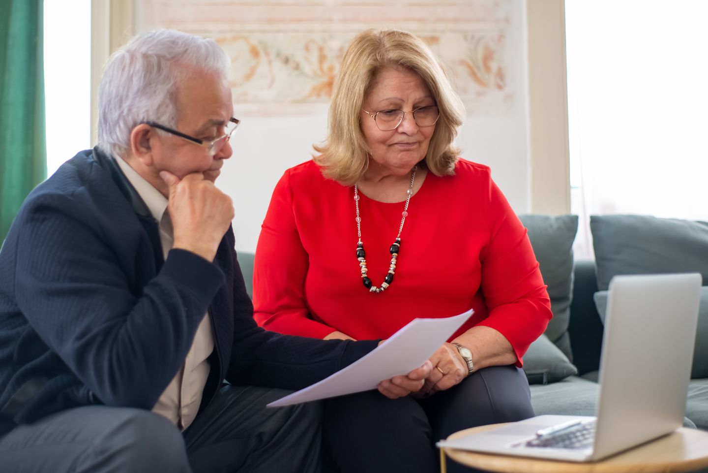 Mature Mexican couple reviewing documents from a social program