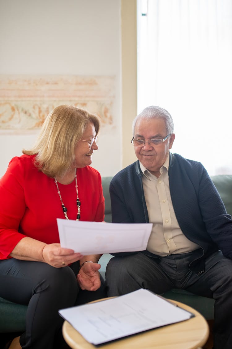 An Elderly Man And Woman Sitting On The Couch While Having Conversation