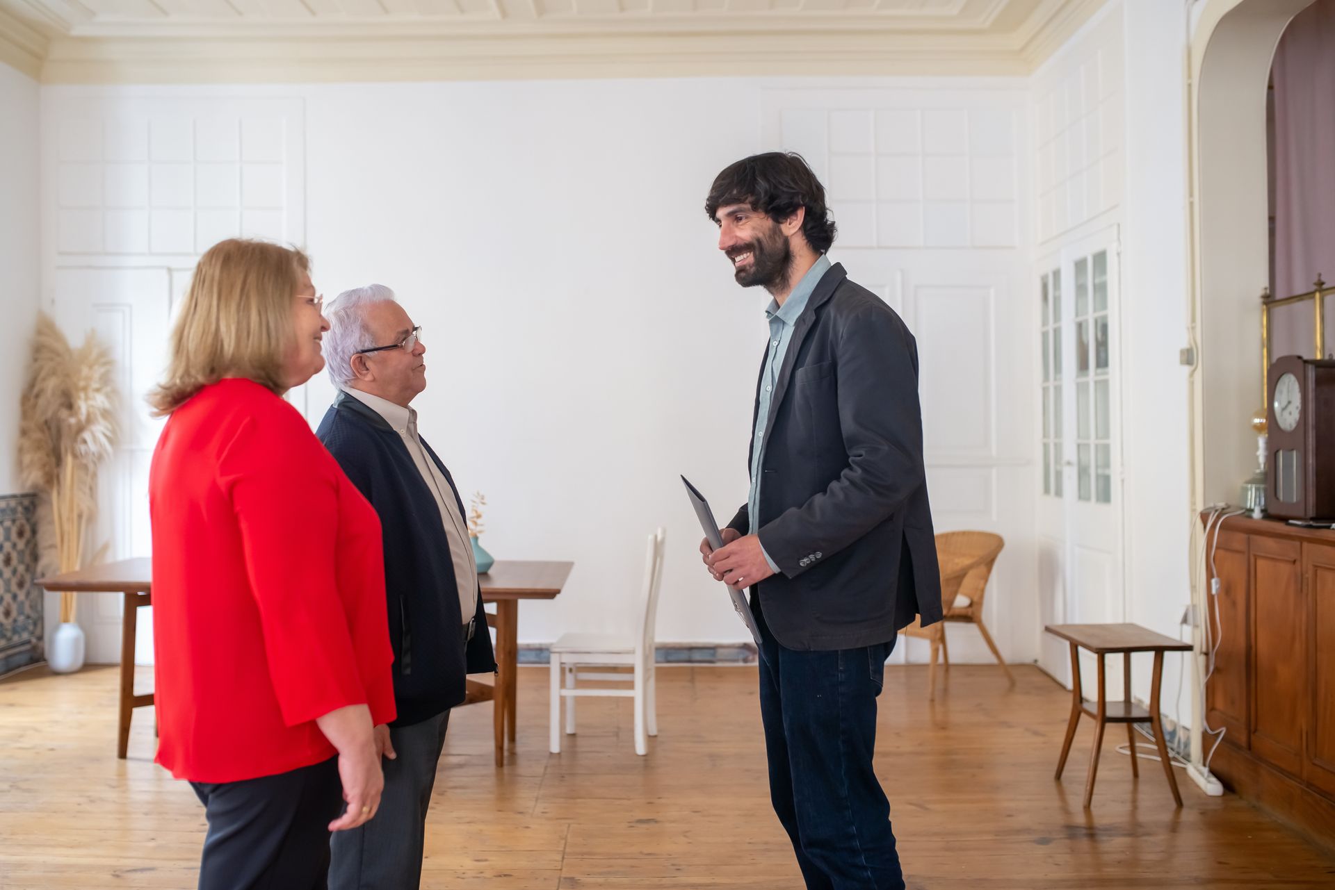 Man in Gray Blazer Talking in Front of Elderly Couple