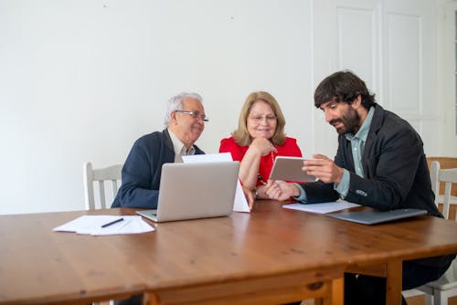 Free Group of People Sitting by the Table Discussing Stock Photo