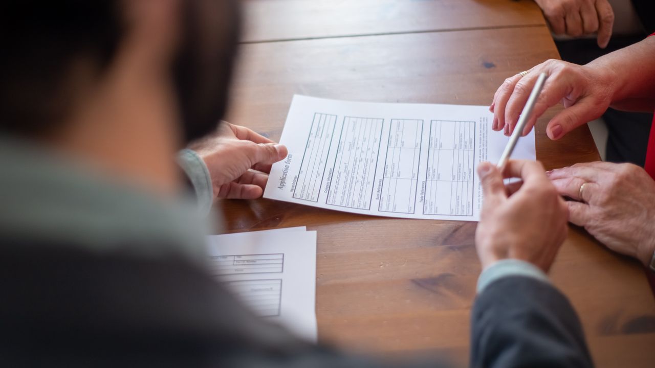 Close-up of business professionals reviewing documents at a meeting.