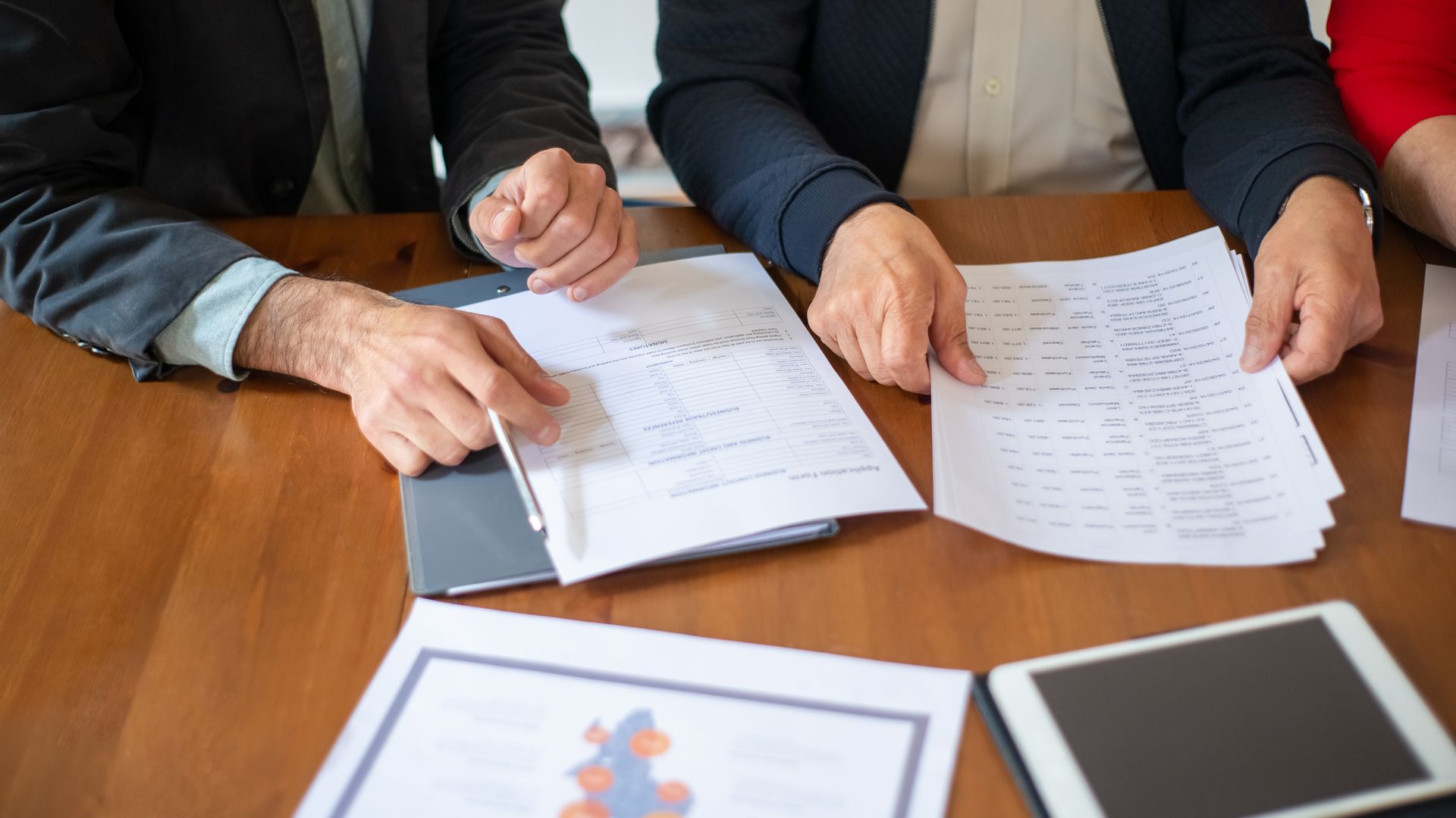Business team reviewing documents together at a meeting — representing a collaborative endoscope parts supplier relationship built on trust and documentation