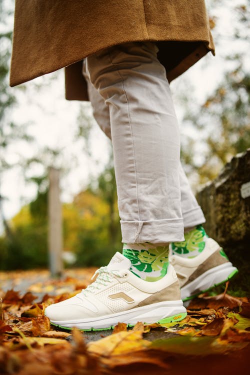 Free Person in White Pants Wearing White and Green Rubber Shoes Stock Photo