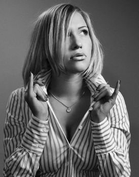 A monochrome portrait of a woman posing with striped long sleeves and a necklace.