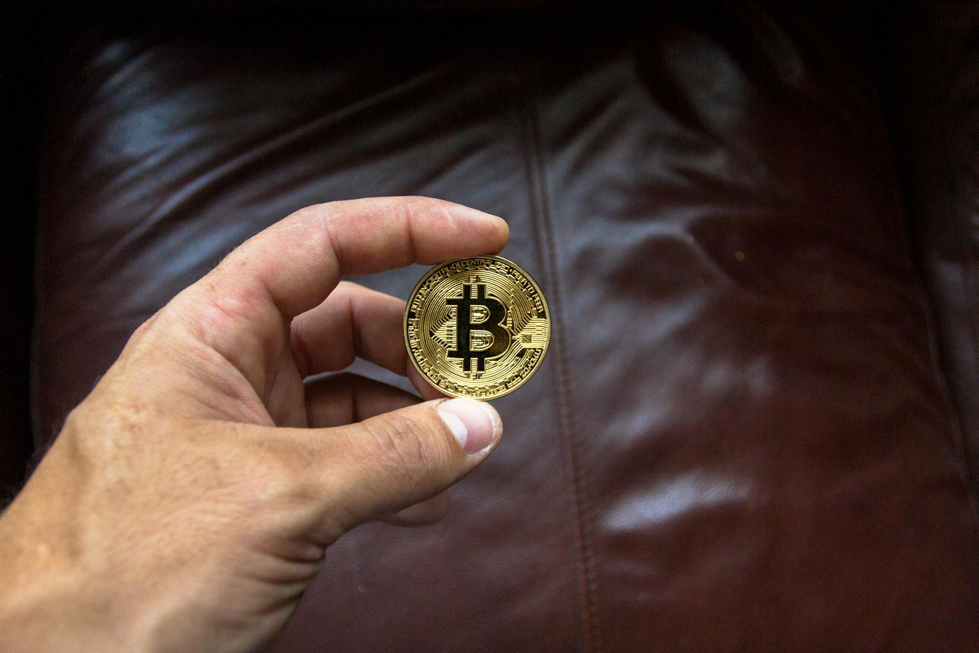 Round Gold-colored and Black Coin on Person's Hand