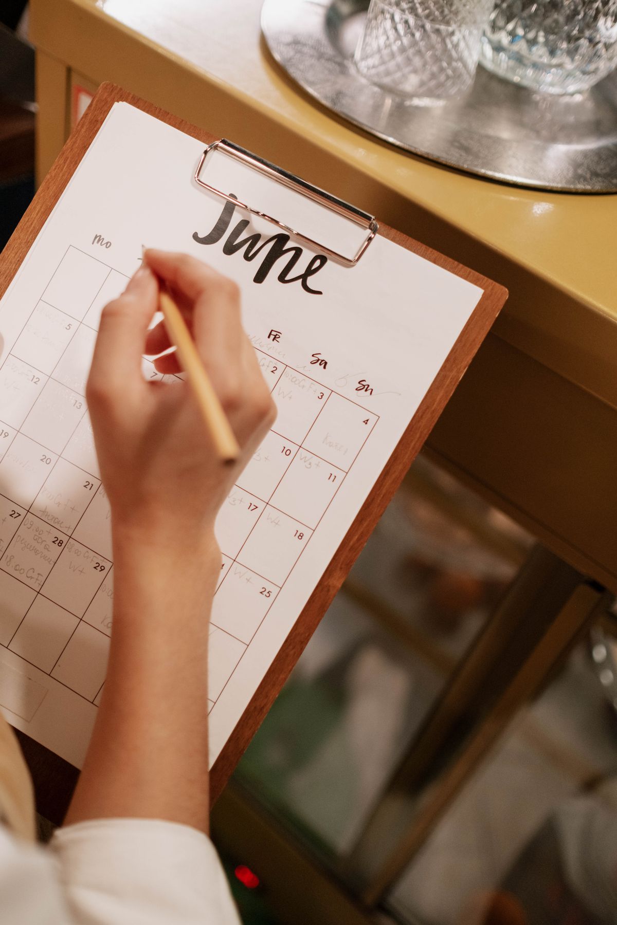Hand writing on a calendar page while planning ahead