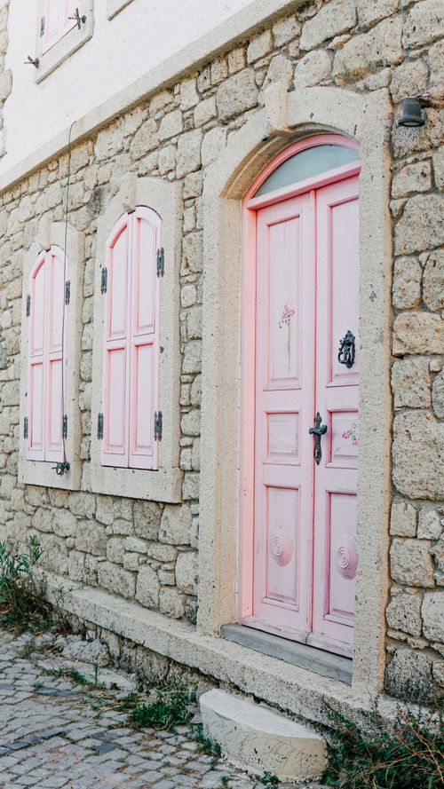 Free Discover a beautiful stone facade with pink doors and shutters in Alaçatı, Türkiye, showcasing unique architecture. Stock Photo