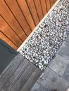 Pebbles and Wood Planks Near a Wooden Wall