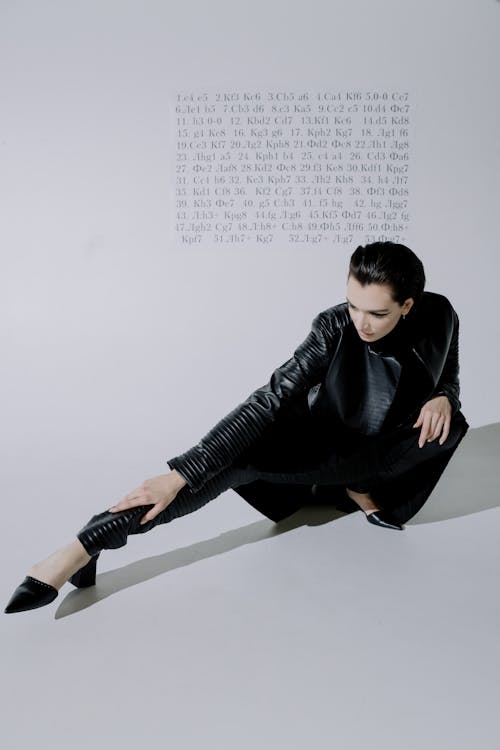 A Model in Leather Outfit Stretching Legs