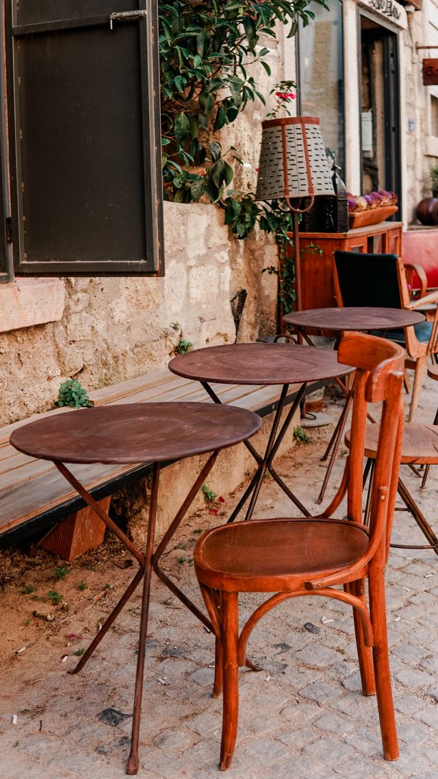 Cafe tables in a narrow old-town street — photo by Melike B on Pexels