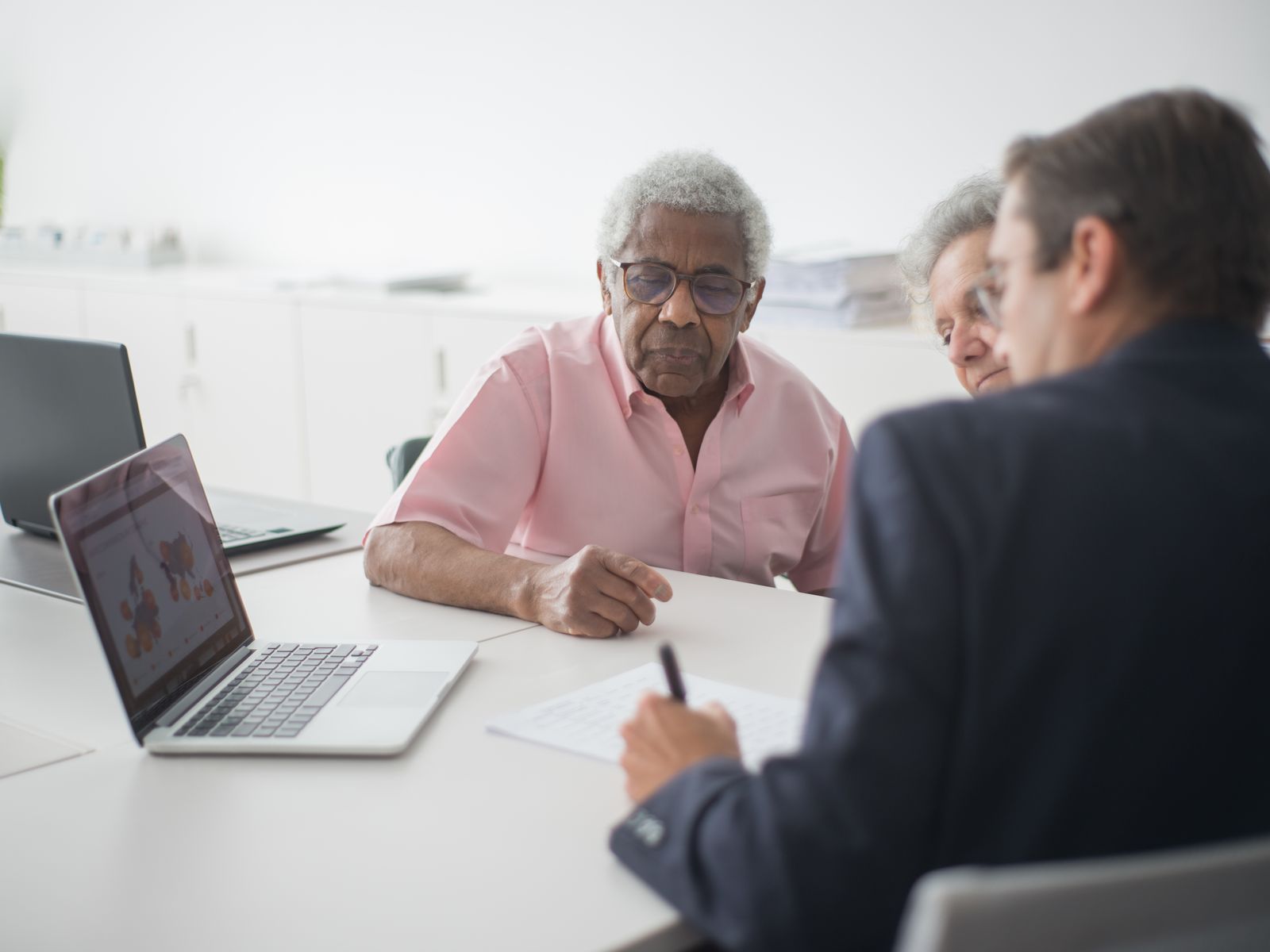 Medicare Help and Retirement Questions Advisor meeting with an older couple to answer Medicare and retirement planning questions