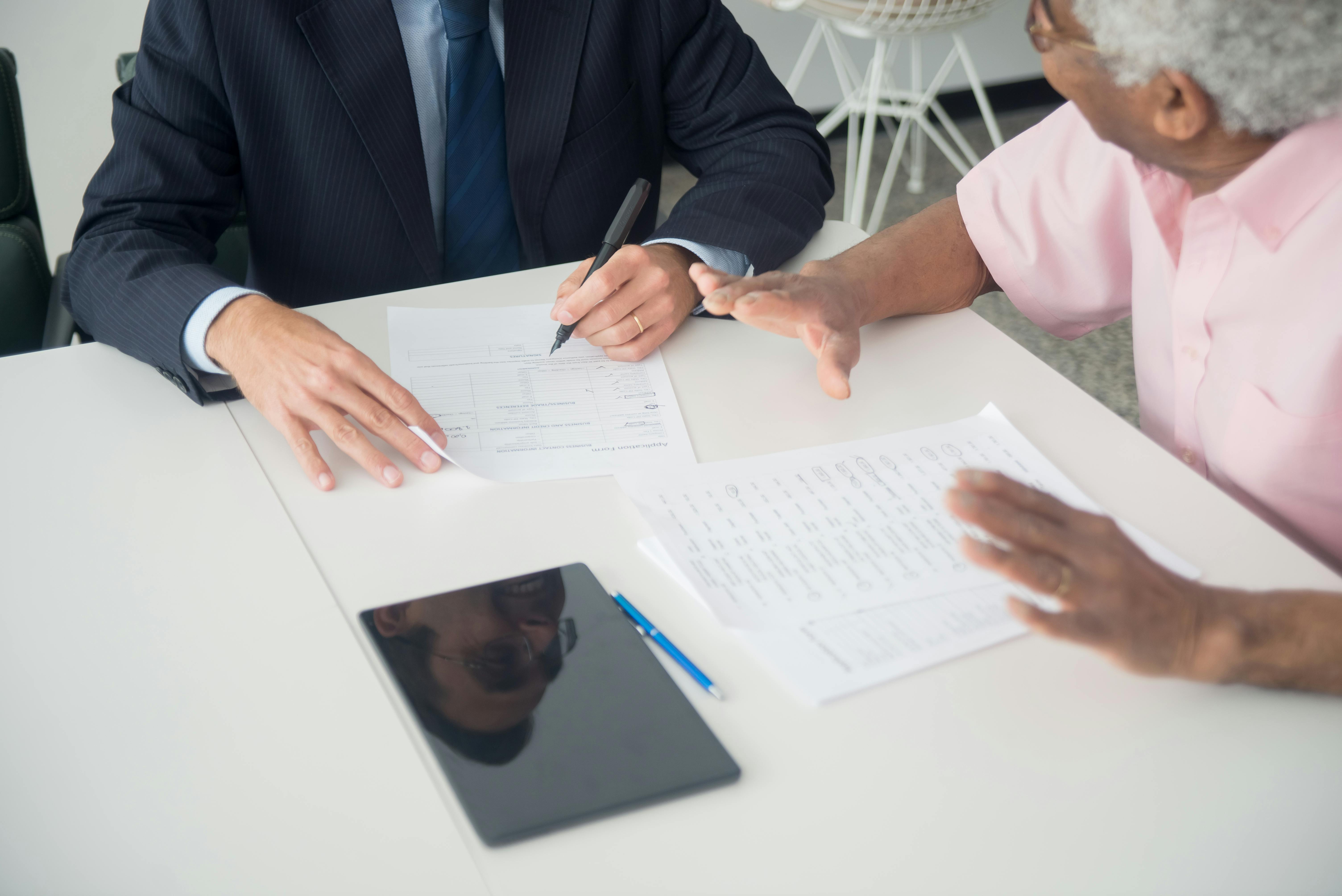 an elderly man consulting an insurance agent